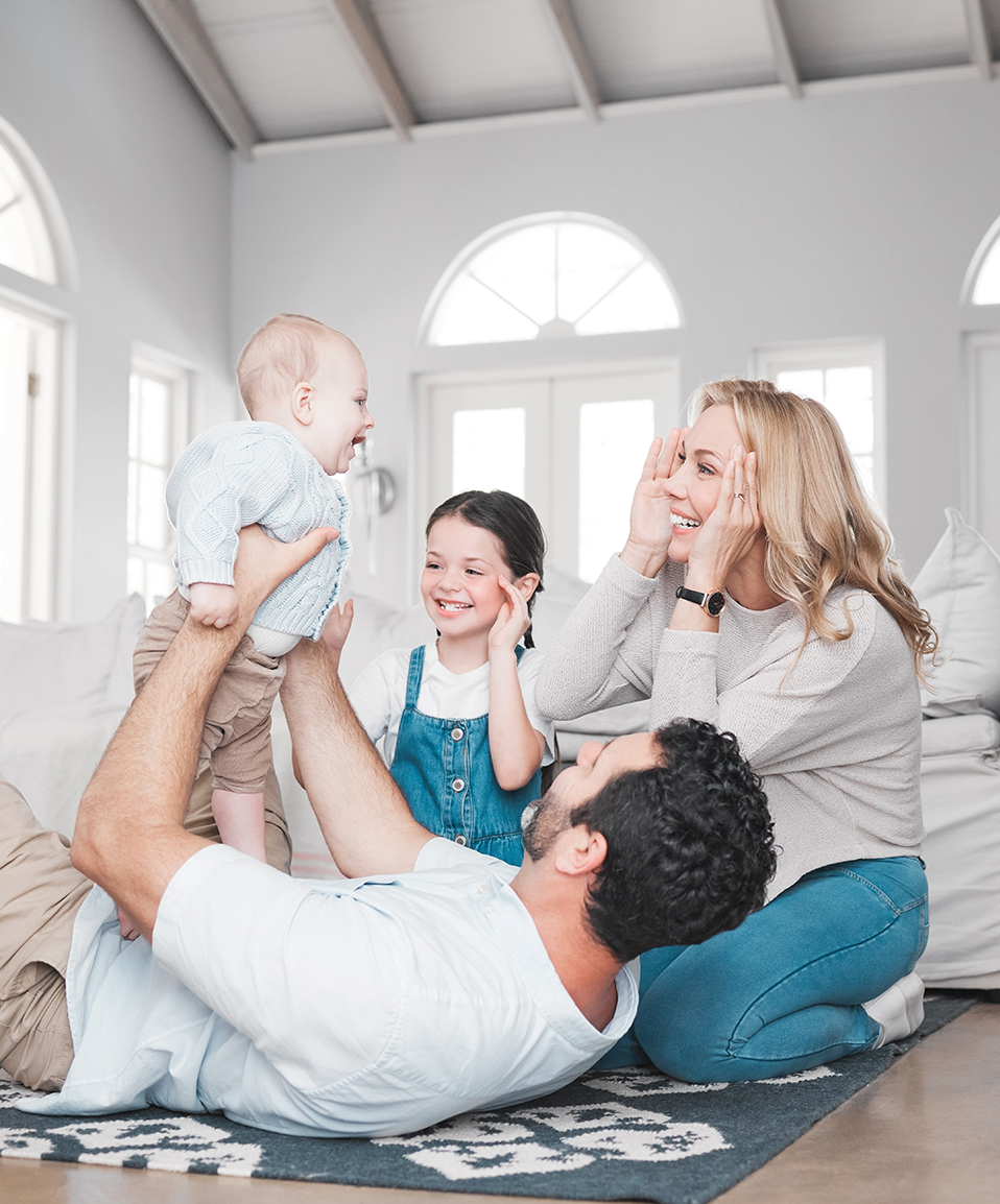 shot of a young family having fun together on the living room floor.